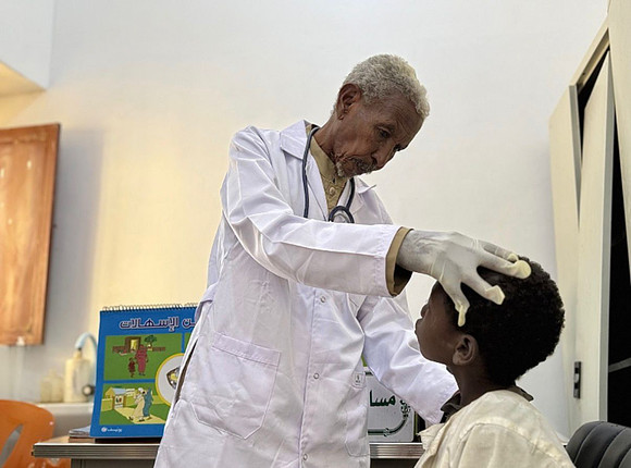 Sudan - thabat project - Medical Assistant in Hagerzagawa examining 12 years old child.